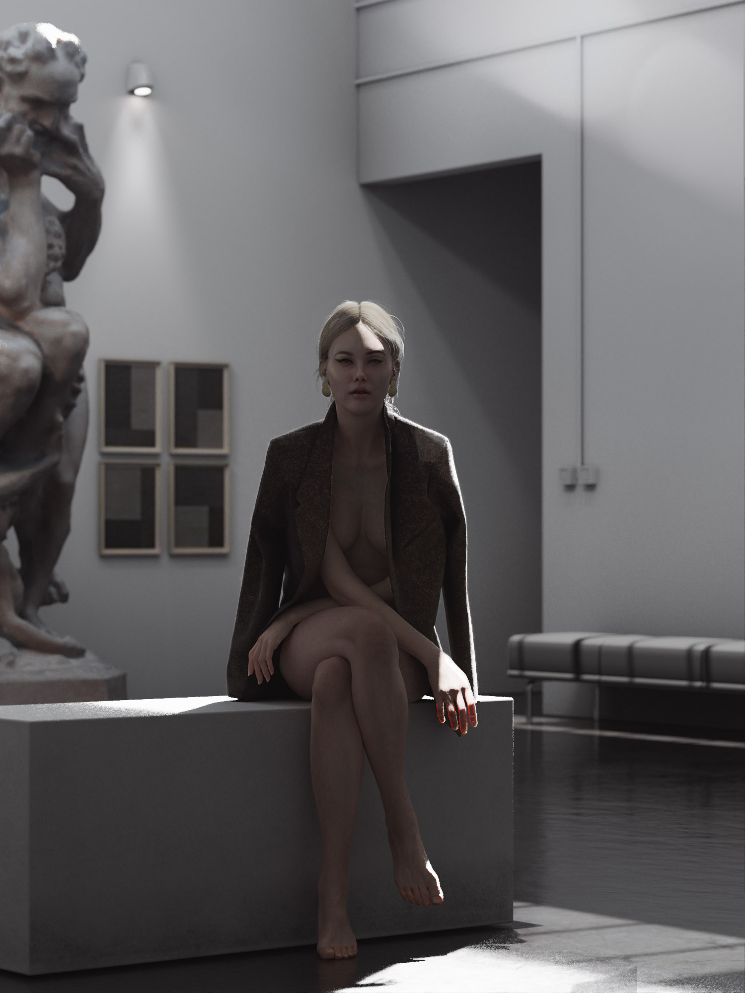 A woman with blonde hair sits contemplatively on a gray block in a minimalist room with a statue to her left and framed artworks on the wall.